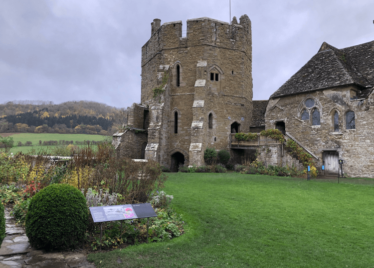 A solidly built tower, with a manicured garden in the foreground